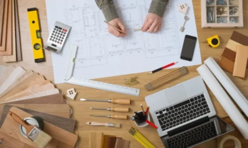 Quantity Surveyors Ireland reviewing architectural floor plans with calculator, laptop, and measurement tools for precise cost estimation